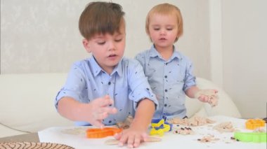 İki küçük çocuğu parayla oynama ve pişirmeyi öğrenme