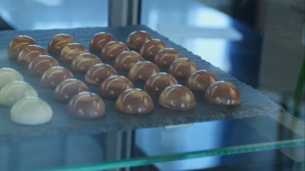 Dulces de chocolate y chocolate blanco en escaparate — Vídeos de Stock