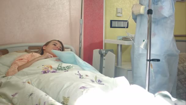 Sjuksköterska i mask och handskar förbereda kvinnliga patienter för dropper — Stockvideo