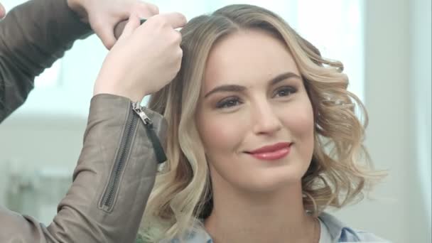 Manos de peluquero están haciendo pequeños rizos, hablando con una joven modelo — Vídeos de Stock