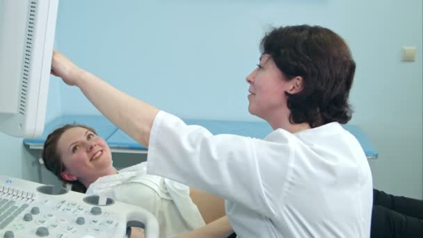 Mujer embarazada sonriente que mira los resultados de la ecografía con el médico — Vídeo de stock