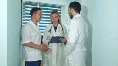 Tartışma sırasında kadın hemşire notlar sahip iki erkek doktor