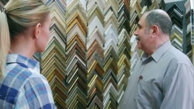 Neşeli gülümseyen kıdemli adam çalışan müşteri atelier çerçevelerde hakkında sohbet