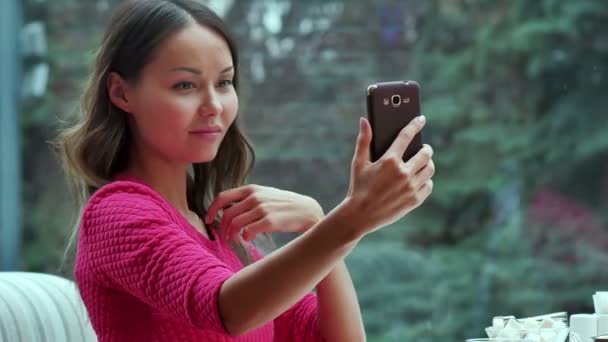 Aantrekkelijke vrouw nemen zelfportret door mobiele telefoon in café — Stockvideo