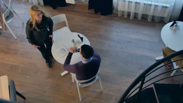 Servitris servering kaffe till ett par — Stockvideo