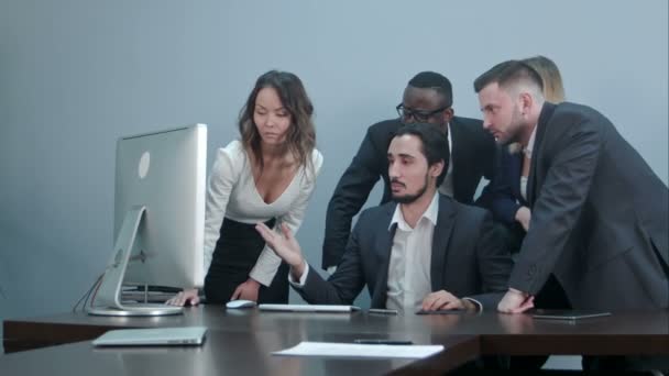 Grupo de empresários multirraciais em torno da mesa de conferência olhando para o computador portátil e conversando uns com os outros — Vídeo de Stock