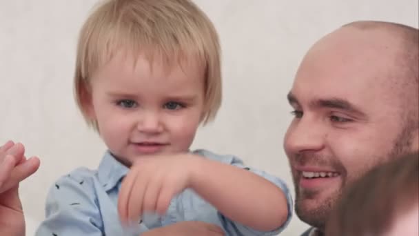 Молодий батько грає зі своїм маленьким сином — стокове відео