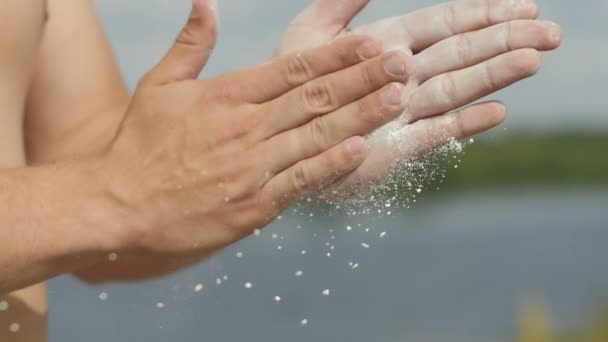 Hombre deportivo cubriéndose las manos con tiza de polvo de magnesio y preparándose para hacer ejercicio — Vídeo de stock