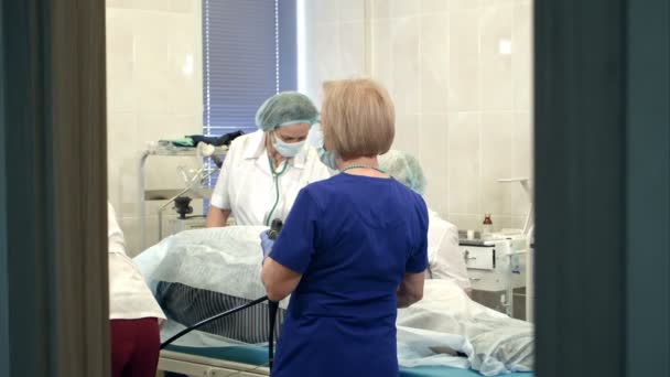 Врачи, управляющие современным эндоскопом во время медицинской процедуры в больнице — стоковое видео