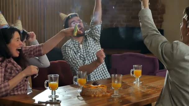 Estudiantes alegres con confeti celebrando fiesta de cumpleaños en un café — Vídeos de Stock