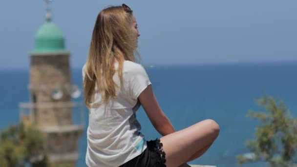 Jonge vrouw in zonnebril genieten van het uitzicht op zee tijdens vakantie — Stockvideo