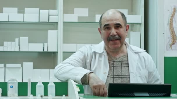 Porträtt av senior apotekspersonal ler och pratar till en kamera — Stockvideo