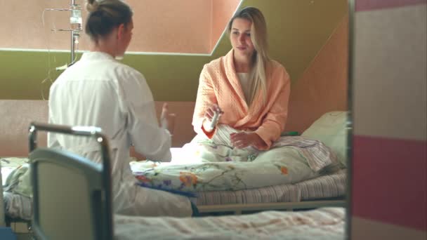 Жіночий багаторасовий лікар дає ліки і воду своєму пацієнту — стокове відео