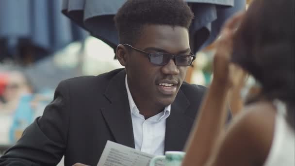 Homme d'affaires afro-américain avec son collègue lisant le menu au restaurant — Video