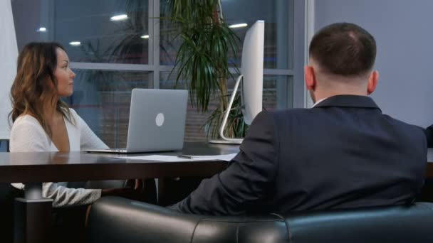 Groep succesvolle zakenmensen praten samen rond een tafel in een kantoordirectiekamer — Stockvideo