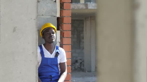 Joven trabajador de la construcción afroamericano toma un descanso durante el trabajo — Vídeo de stock