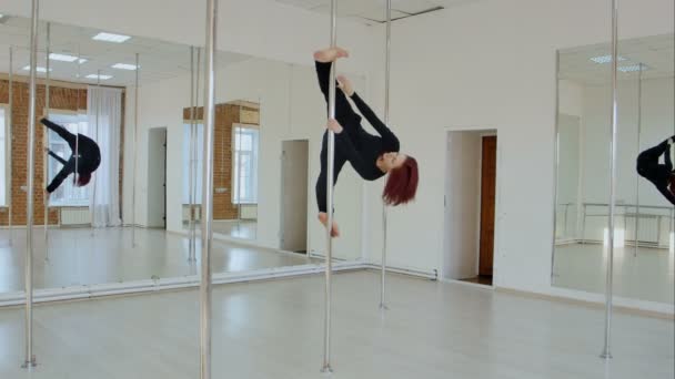 Young pole dance woman in black clothes can not hold herself in pose on pylon — Stock Video