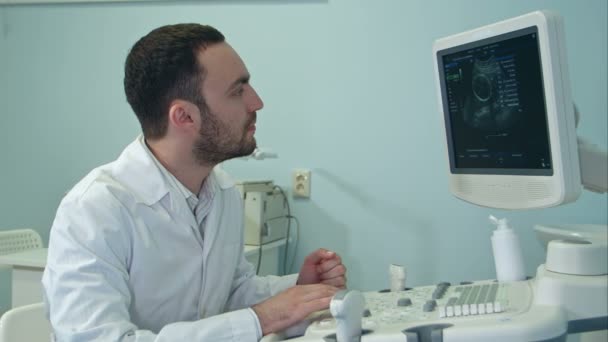 Jovem médico com máquina de diagnóstico de ultra-som — Vídeo de Stock