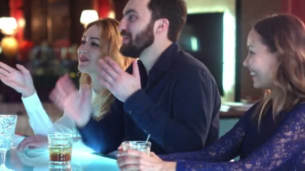 Felice e attraente gruppo di amici che chiacchierano e ridono insieme in un bar — Video Stock
