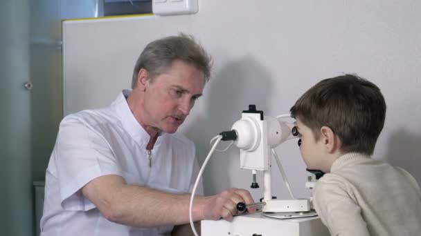 Optometrista che controlla la visione del bambino — Video Stock