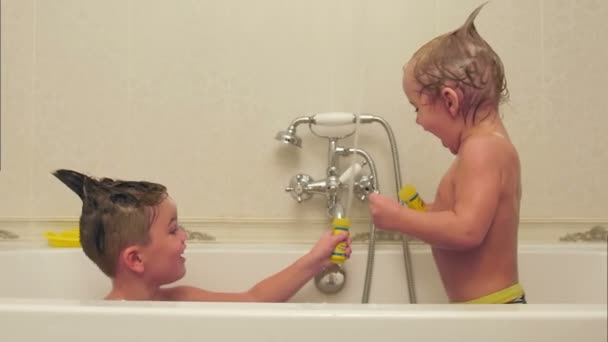 Два маленьких мальчика развлекаются, принимая ванну — стоковое видео