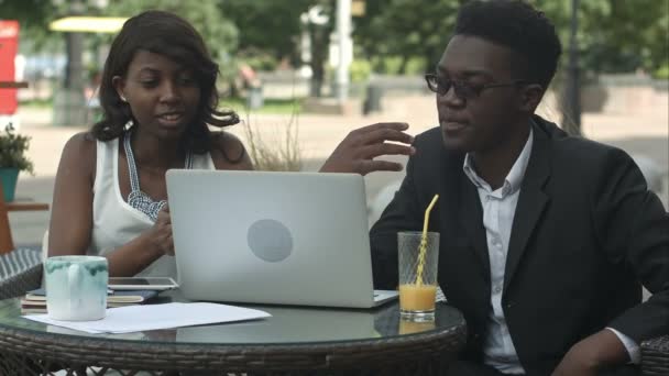 Equipo de negocios afro-americano cansado y sobrecargado de trabajo sentado en la cafetería con computadora portátil — Vídeo de stock