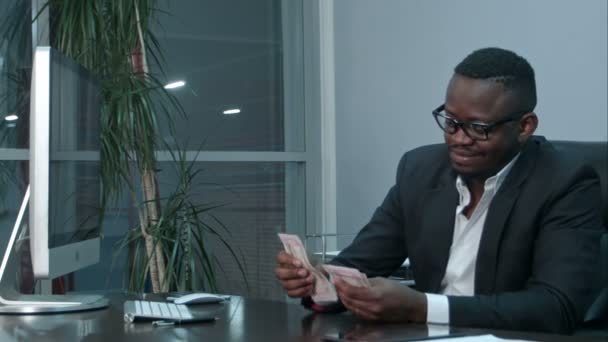 Homme d'affaires afro comptant l'argent comptant, assis au bureau — Video