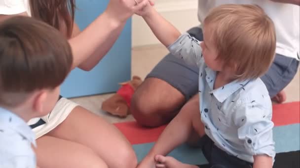 Jonge ouders hun kleine zonen onderwijzen hoe te spelen met vinger marionetten — Stockvideo