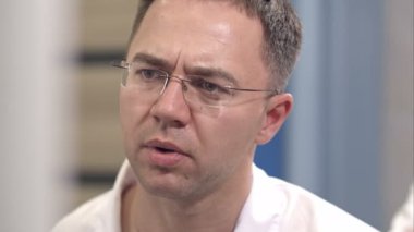 Ciddi erkek cerrah cerrahi endoskop ekrana bakarak kontrol