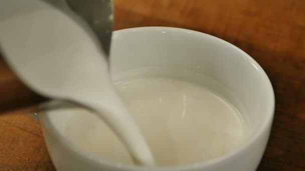 Ρίχνει το γάλα σε ένα φλυτζάνι του καφέ — Αρχείο Βίντεο