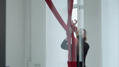 Güzel direk dansör egzersiz yaparak kırmızı hava kumaş üzerine