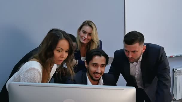 Jóvenes empresarios sorprendidos mirando el monitor de computadora en la oficina — Vídeo de stock