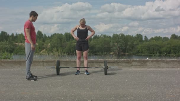 Vonzó nő képzés segítségével a személyi edző szabadban — Stock videók