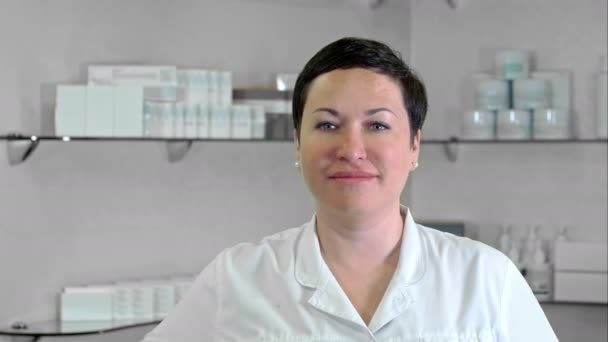 Улыбающийся доктор смотрит в камеру в медицинском кабинете — стоковое видео