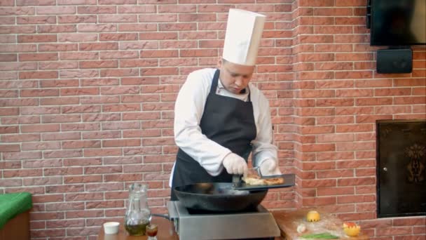 Шеф-повар кладет жареные пельмени с морепродуктами на тарелку — стоковое видео