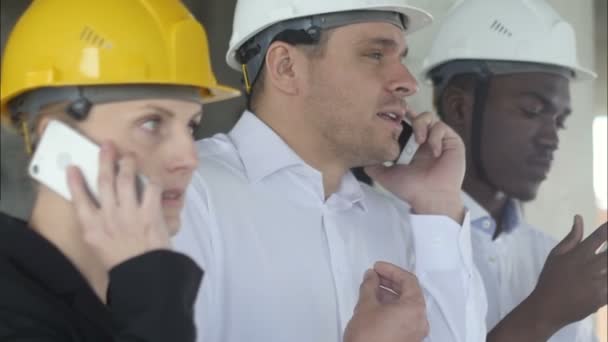 Verärgerter Teambuilder telefoniert bei Geschäftstreffen auf Baustelle — Stockvideo