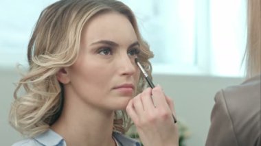 Göz gölgeler uygulamak için makyaj fırça kullanarak