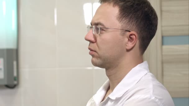 Концентрированный хирург-мужчина в очках — стоковое видео