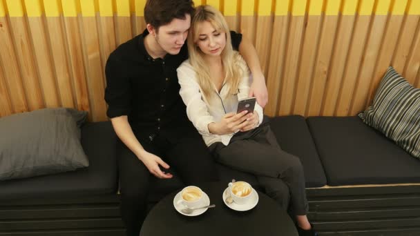 Casal jovem tirando uma foto de si mesmos em um café — Vídeo de Stock