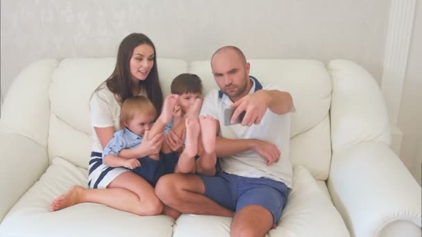 Familia feliz tomando selfies divertidos en el teléfono sentado en el sofá — Vídeos de Stock