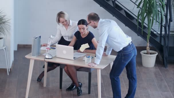 Groupe de heureux divers hommes et femmes d'affaires dans les gens d'affaires formels réunis autour de l'ordinateur portable dans un bureau lumineux — Video