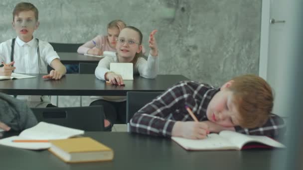 Basisschool kinderen werken in de klas met leraar — Stockvideo