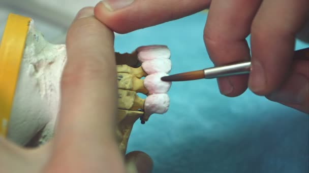 Dental technician applying ceramics glaze to a cast made with CNC dental machine — Stock Video