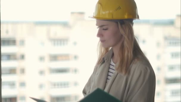 Γυναίκα αρχιτέκτονας Κοιτάζοντας προσεκτικά το σχέδιο για το εργοτάξιο — Αρχείο Βίντεο