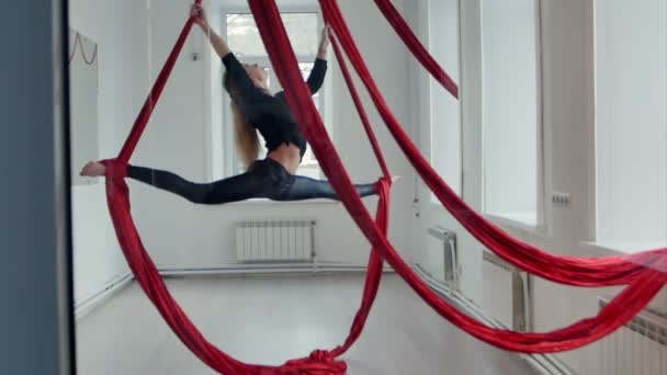 Slanke vrouwelijke pool danser doen bindgaren met aerial silk — Stockvideo