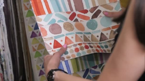 Звичайна жінка вибирає цікаву тканину в текстильному магазині — стокове відео