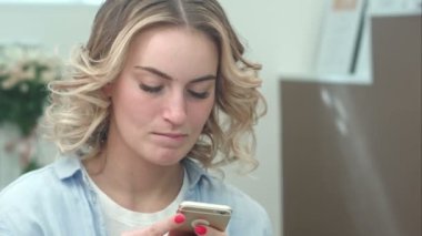 Dalgın genç kadın sabah salonunda cep telefonu kullanmak