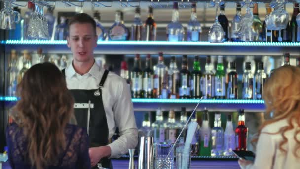 Симпатичный бармен, подающий коктейль красивой женщине в стильном баре — стоковое видео