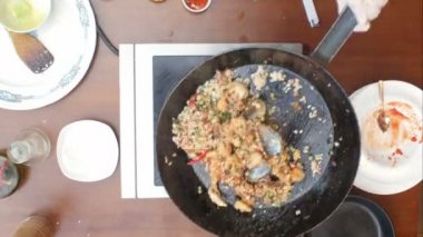 Karıştırma paella ve deniz ürünleri bir tavada pişirme