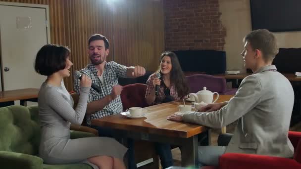 Amigos felices cantando karaoke juntos en un bar — Vídeo de stock
